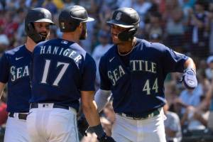 Seattle Mariners' Mitch Haniger, center, is congratulated by Jesse Winker, left, and Julio Rodriguez after hitting a three-run home run off Cleveland Guardians starting pitcher Triston McKenzie during the first inning of a baseball game, Thursday, Aug. 25, 2022, in Seattle. (AP Photo/Stephen Brashear)