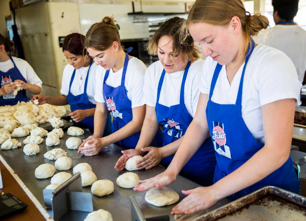 Fisher employees mold scone dough during opening day of the Evergreen State Fair on Aug. 25. (Olivia Vanni / The Herald)