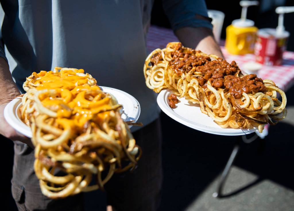 Dont go on a scary carnival ride after downing a plate of curly fries loaded with cheese (left) or chili. (Olivia Vanni / The Herald)