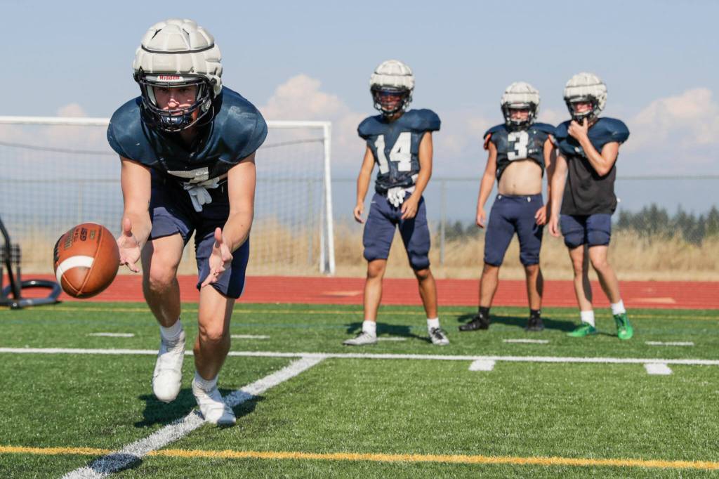 Glacier Peaks Logan Szarzec reaches low for a pass during practice Thursday afternoon at Glacier Peak High School in Snohomish. (Kevin Clark / The Herald)