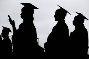 FILE - In this May 17, 2018, file photo, new graduates line up before the start of the Bergen Community College commencement at MetLife Stadium in East Rutherford, N.J.  There’s no single policy or action that will alleviate America’s $1.74 trillion student loan debt crisis while simultaneously preventing students from taking on unaffordable amounts of future debt. Higher education financing experts are divided on the exact combination of solutions, but all agree it will require a multipronged approach.  (AP Photo/Seth Wenig, File)