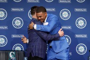 Seattle Mariners' Julio Rodriguez hugs Mariners President of Baseball Operations Jerry Dipoto at the end of a news conference held a day after announcing he signed a multi-year contract, Saturday, Aug. 27, 2022, in Seattle. (AP Photo/John Froschauer)
