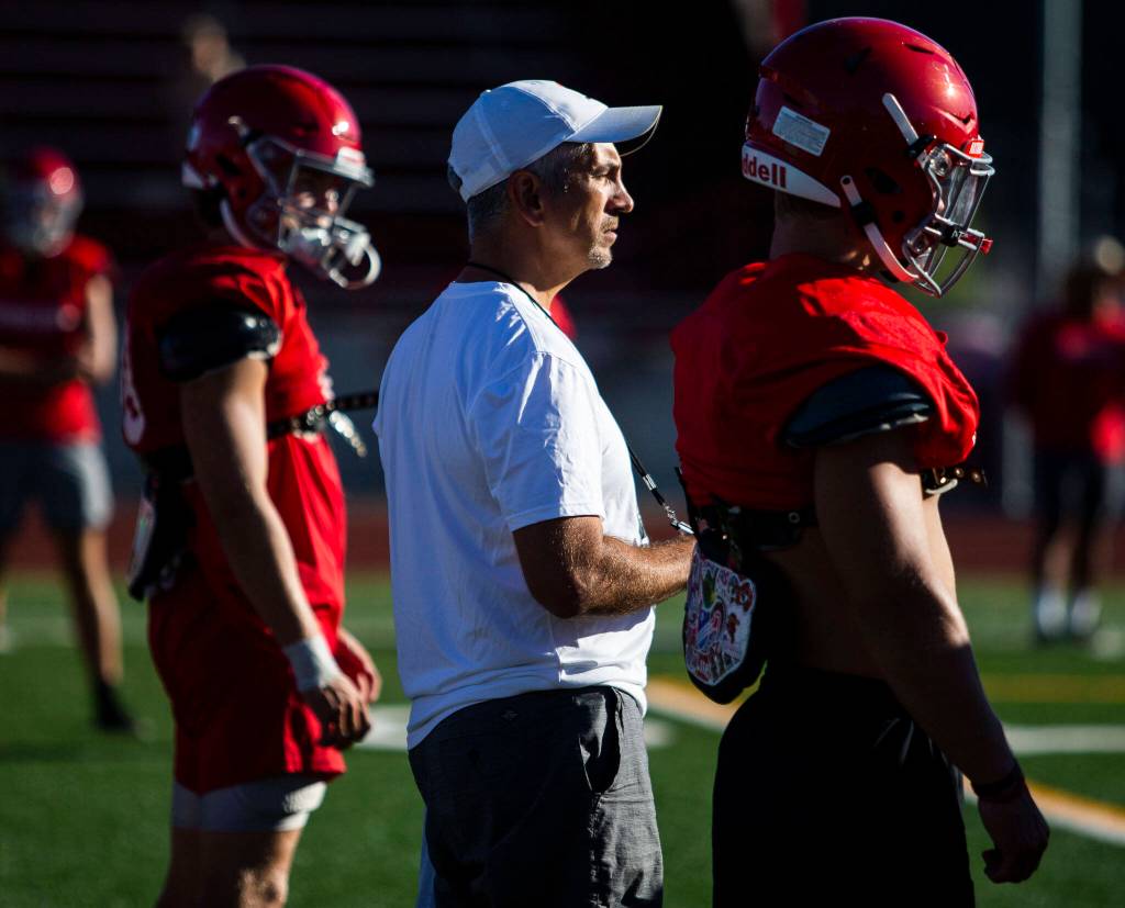 Stanwood head coach Jeff Scoma watches drills during practice Monday, Aug. 29, 2022 in Stanwood. (Olivia Vanni / The Herald)