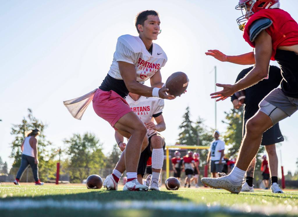 Stanwoods Wyatt Custer works on handoffs during practice Monday, Aug. 29, 2022 in Stanwood. (Olivia Vanni / The Herald)