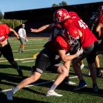 Stanwoods Caden Caldero hits teammate Eli Fleck during practice Monday, Aug. 29, 2022 in Stanwood. (Olivia Vanni / The Herald)