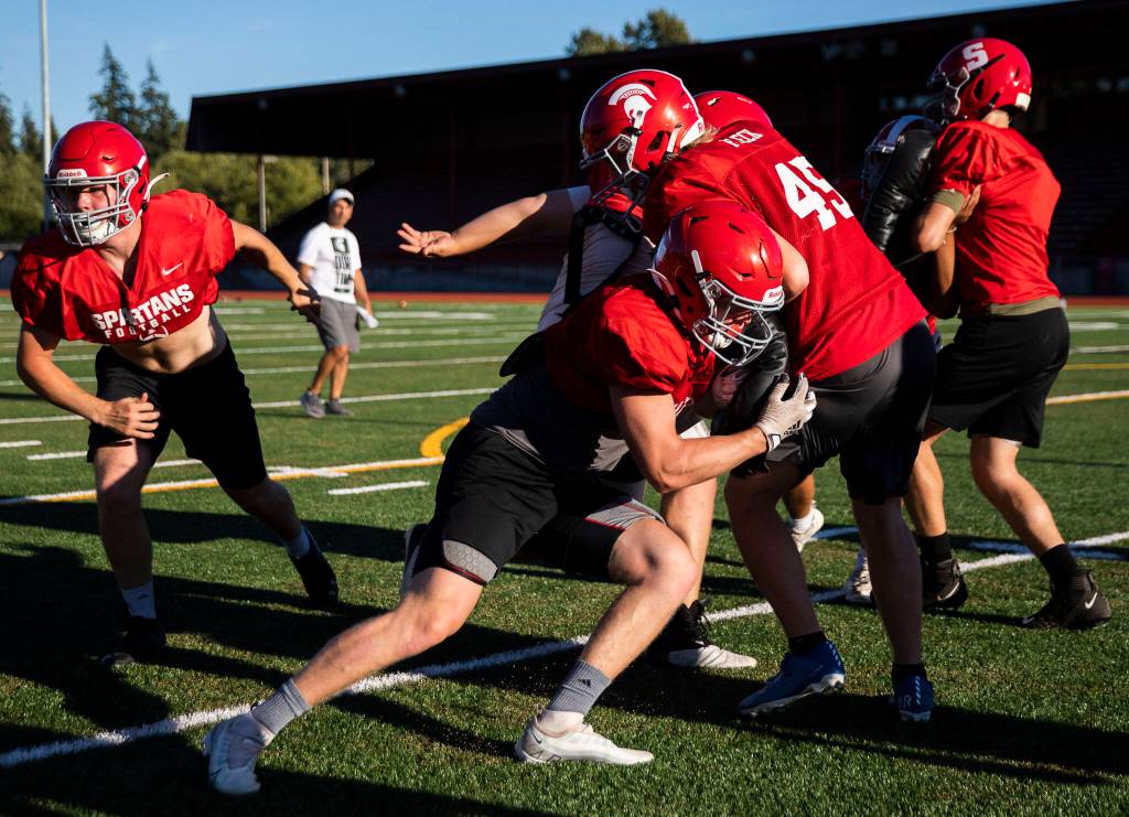 Stanwoods Caden Caldero hits teammate Eli Fleck during practice Monday, Aug. 29, 2022 in Stanwood. (Olivia Vanni / The Herald)