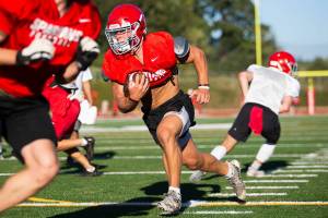 Stanwood’s Ryder Bumgarner runs the ball during football practice on Monday, Aug. 29, 2022 in Stanwood, Washington. (Olivia Vanni / The Herald)