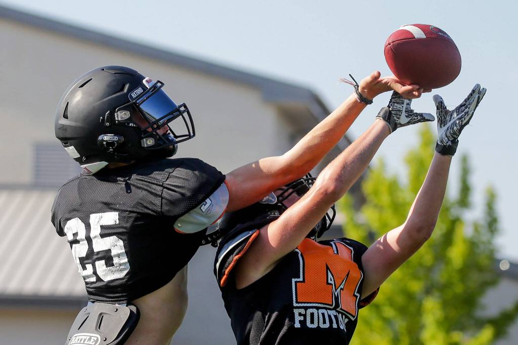 Trent Bublitz, left and Braden Bingham jump for a reception during practice at Monroe High School Tuesday afternoon in Monroe, Washington on August 30, 2022. (Kevin Clark / The Herald)