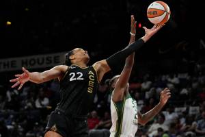 Las Vegas Aces forward A'ja Wilson (22) and Seattle Storm guard Jewell Loyd (24) battle for a rebound during the first half in Game 2 of a WNBA basketball semifinal playoff series Wednesday, Aug. 31, 2022, in Las Vegas. (AP Photo/John Locher)