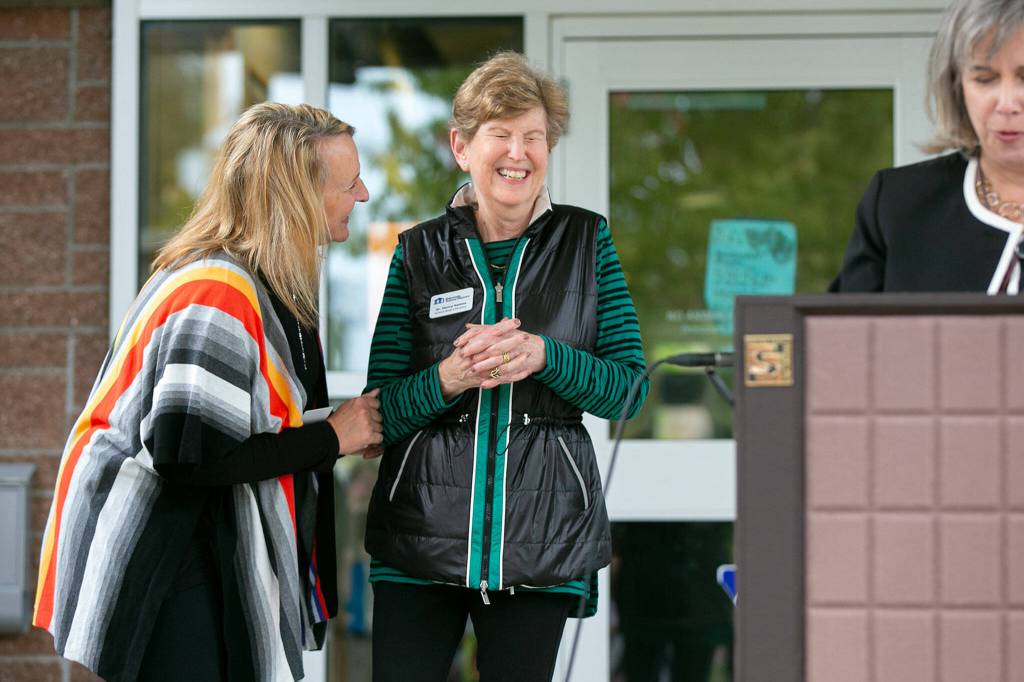 Assistant Superintendent Dana Geaslen, left, laughs with School Board Director Dr. Nancy Katims after Katims cut the ceremonial ribbon for the new school health center at Meadowdale High School on Wednesday, in Lynnwood. (Ryan Berry / The Herald)