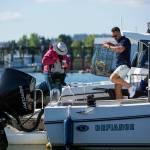 Sean Jones, membership executive of Everetts Freedom Boat Club, helps club member Carolyn Duncan load equipment onto her boat before she and a friend head out crabbing on Aug. 11, at the Port of Everett in Everett. (Ryan Berry / The Herald)