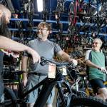 Devin Ryan, left to right, talks with Donald Whitley and Drew Yager before a test ride at Bicycle Centres Wednesday in Everett, Washington on August 24, 2022.  (Kevin Clark / The Herald)