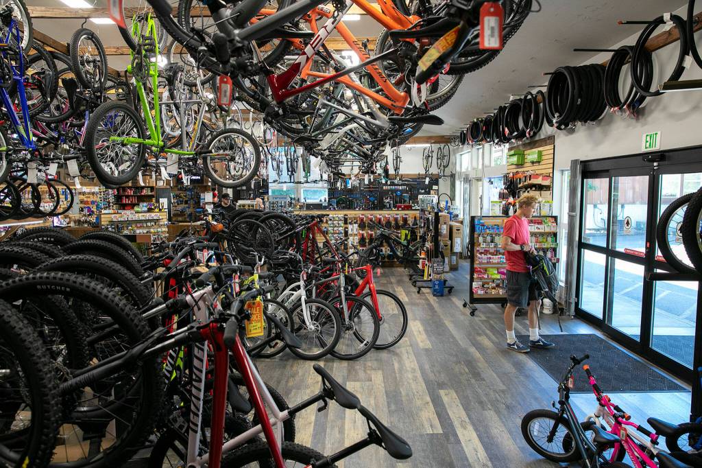 A customer heads out after dropping of their bicycle to be serviced Wednesday, Aug. 24, 2022, at Bicycle Centres of Snohomish in Snohomish, Washington. (Ryan Berry / The Herald)
