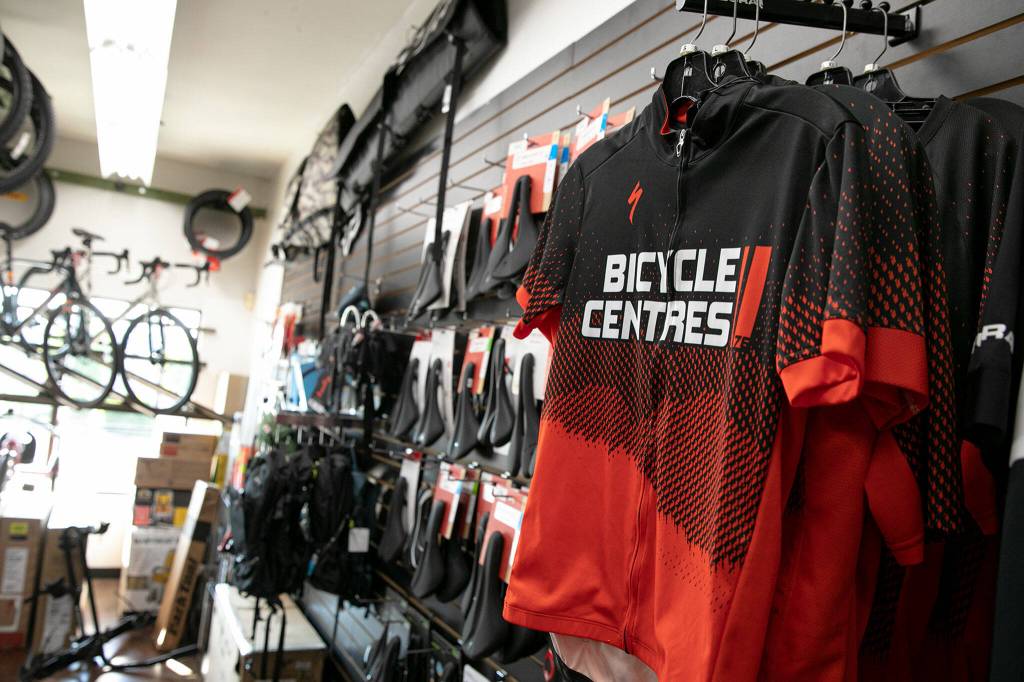 Bicycle Centres branded merchandise hangs on the wall Thursday, Sep. 1, 2022, at Bicycle Centres of Silverlake in Everett, Washington. (Ryan Berry / The Herald)