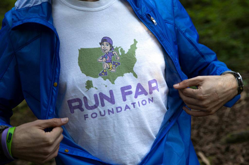 Greg Nance shows off his Run Far Fo shirt while walking along a trail Tuesday, at the Mount Pilchuck Trailhead near Verlot. (Ryan Berry / The Herald)