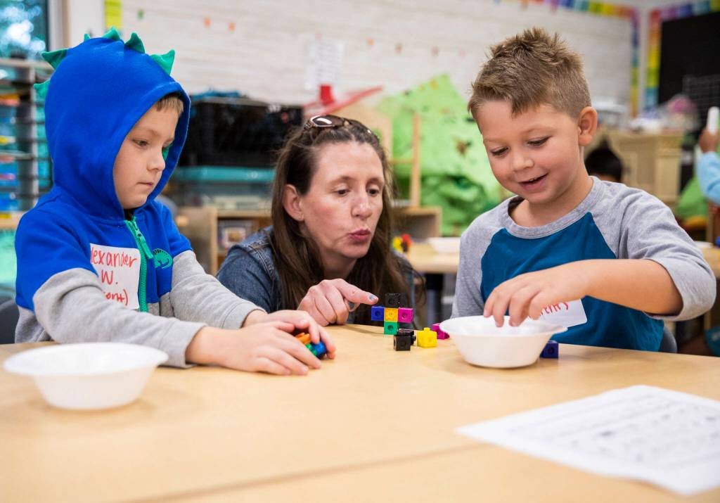 Alexander Williams, left, and Finn Botts, right, do a counting exercise with the help of Janet Chapman-Ruland on Friday, Aug. 26, 2022, near Everett, Washington. (Olivia Vanni / The Herald)