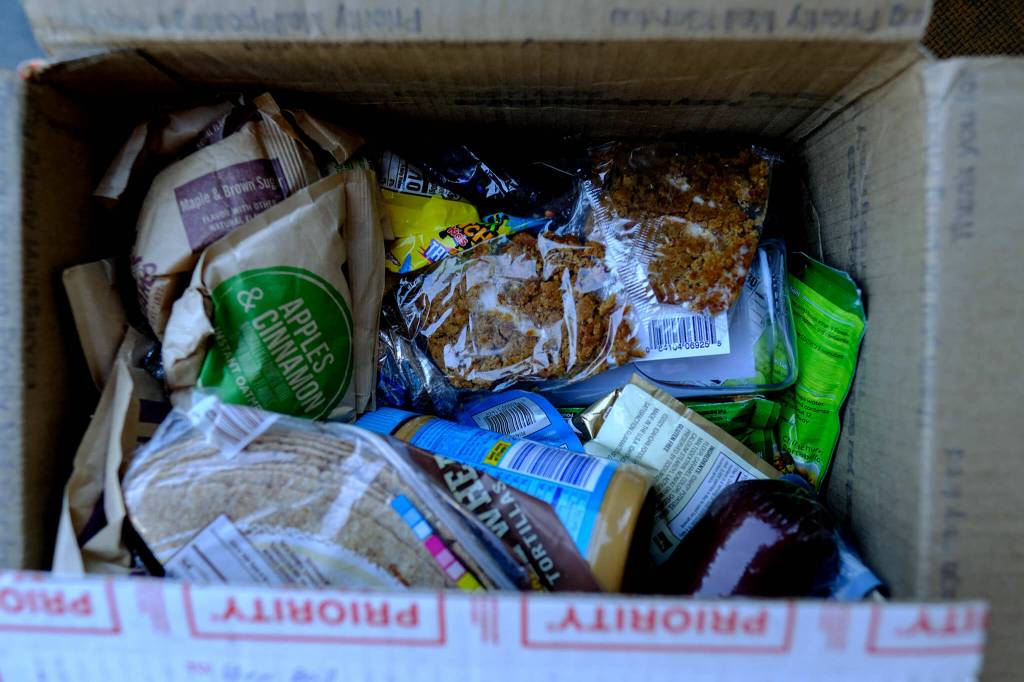 A typical resupply box for a thru-hiker, this one contains peanut butter, Sour Patch Kids, instant oatmeal, tortillas, instant mashed potatoes, Pop-Tarts, granola bars, tuna packets, cured meats and more. (Taylor Goebel / The Herald)