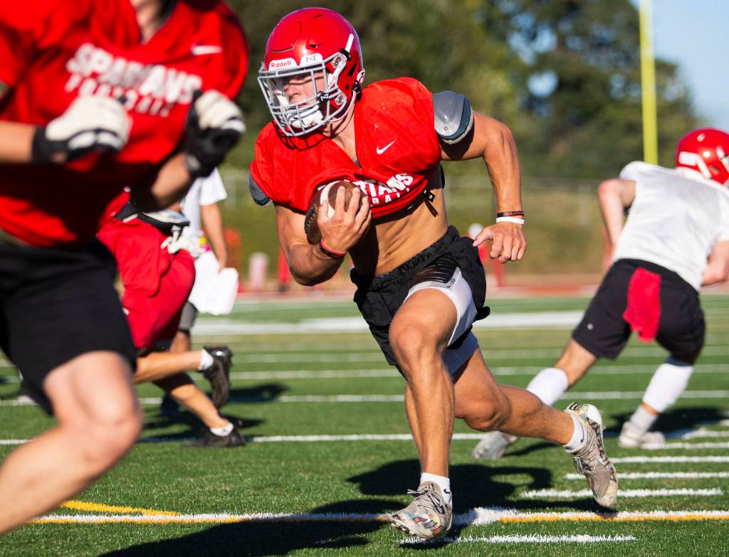 Stanwood’s Ryder Bumgarner runs the ball during football practice on Monday, Aug. 29, 2022 in Stanwood, Washington. (Olivia Vanni / The Herald)