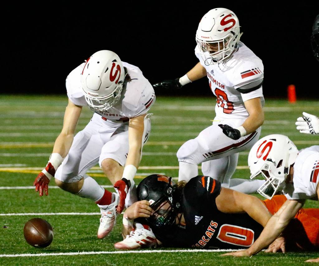 Snohomish's Kaden Alexander gathers a loose ball from a punt Friday night at Monroe High School on October 22, 2021.  (Kevin Clark / The Herald)