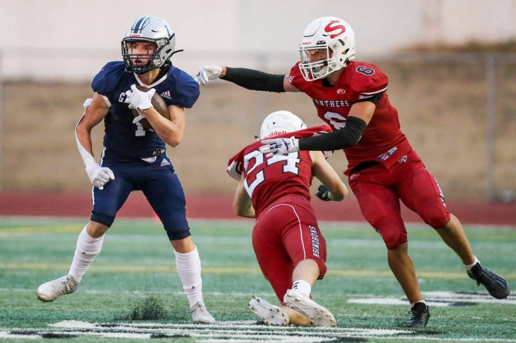 Glacier Peaks Gabe Russel, left, avoids a tackle by Snohomishs Easton Leonard (24) and Parker Jackson Friday night at Snohomish High School in Snohomish, Washington on September 2, 2022. Glacier Peak led 28-0 at the half. (Kevin Clark / The Herald)