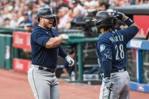 Seattle Mariners' Ty France, left, is congratulated by Eugenio Suarez after hitting a solo home run off Cleveland Guardians starting pitcher Xzavion Curry during the first inning of a baseball game in Cleveland, Saturday, Sept. 3, 2022. (AP Photo/Phil Long)