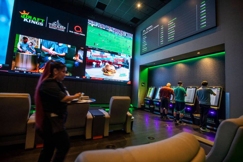 People lineup to place bets at the kiosks during the soft opening of the DraftKings Sportsbook at the Tulalip Casino on Tuesday, in Tulalip. (Olivia Vanni / The Herald)