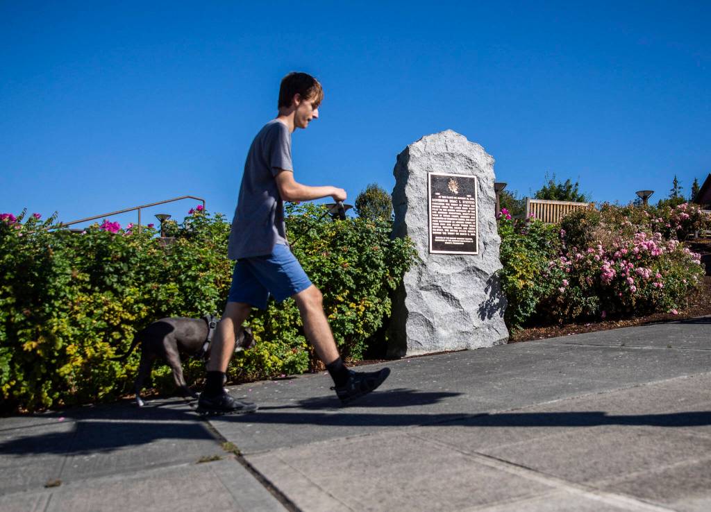 A pedestrian walks past the replacement Point of Elliot Treaty marker on Wednesday, Sept. 7, 2022 in Mukilteo, Washington. (Olivia Vanni / The Herald)