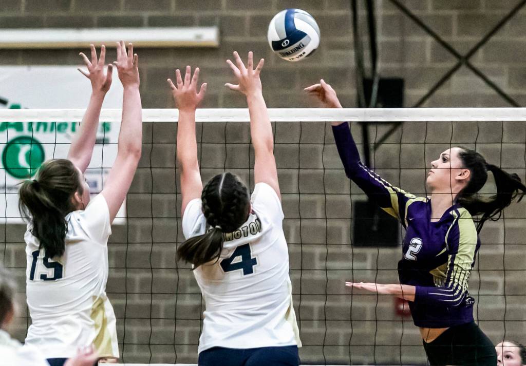Lake Stevens Bella Christensen, right, attempts a kill with Arlingtons Caitlin Klein, left, and Cadynce Knudson blocking Tuesday evening at Arlington High School in Arlington, Washington on September 6, 2022. The Vikings won the straight sets. (Kevin Clark / The Herald)