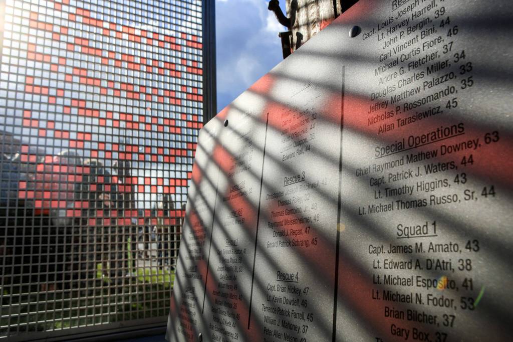 Morning sun streams through a portion of The Fallen Firefighter Memorial highlighting names of the fallen in Edmonds on Sept. 11, 2016. (Kevin Clark / The Herald)