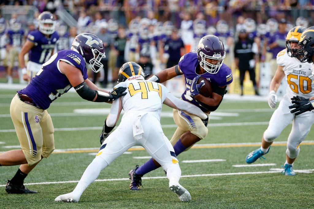 Lake Stevens Jayden Limar takes a carry right at the defense against Bellevue on Friday, Sep. 9, 2022, at Lake Stevens High School in Lake Stevens, Washington. (Ryan Berry / The Herald)