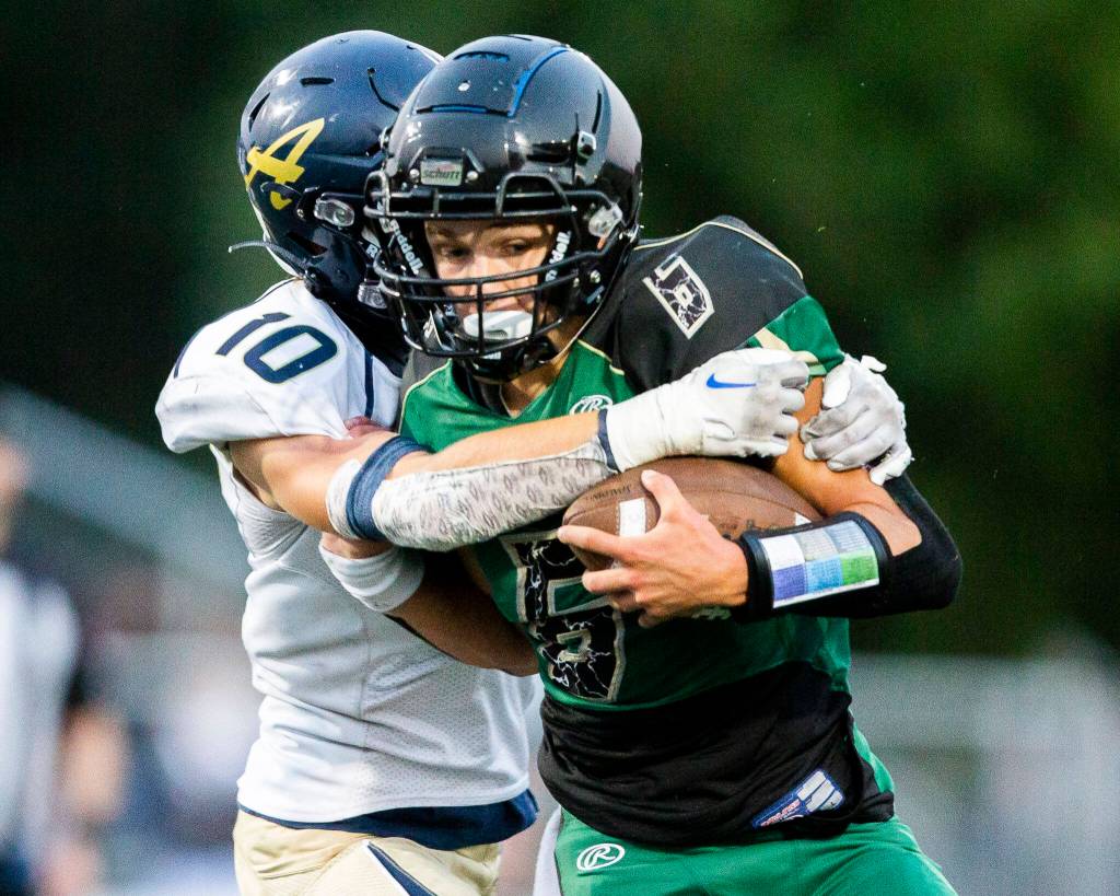 Marysville Getchells Carter Schmidt is tackled by Arlingtons Caiden Patterson during the game on Friday, Sept. 9, 2022 in Marysville, Washington. (Olivia Vanni / The Herald)
