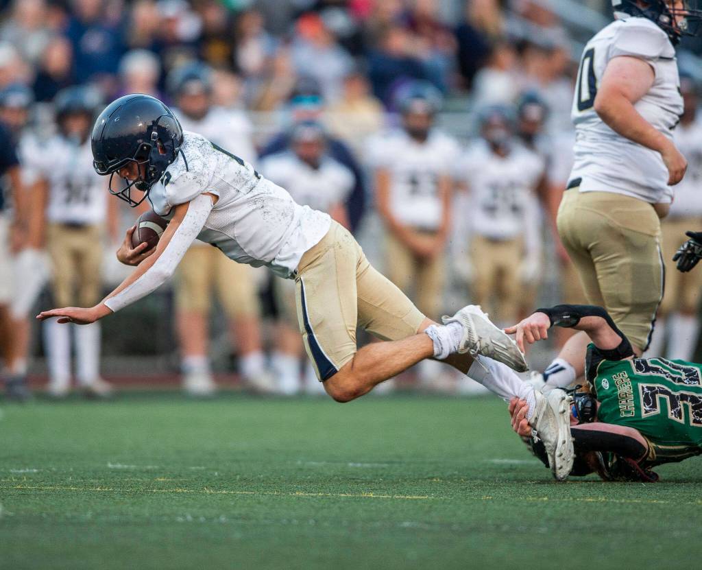 Arlingtons Jacoby Falor is tackled by Marysville Getchells Samuel Gooch during the game on Friday, Sept. 9, 2022 in Marysville, Washington. (Olivia Vanni / The Herald)