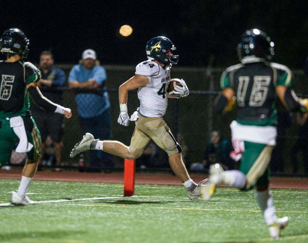 Arlingtons Spencer Fischer runs the ball in for a touchdown during the game against Marysville Getchell on Friday, Sept. 9, 2022 in Marysville, Washington. (Olivia Vanni / The Herald)