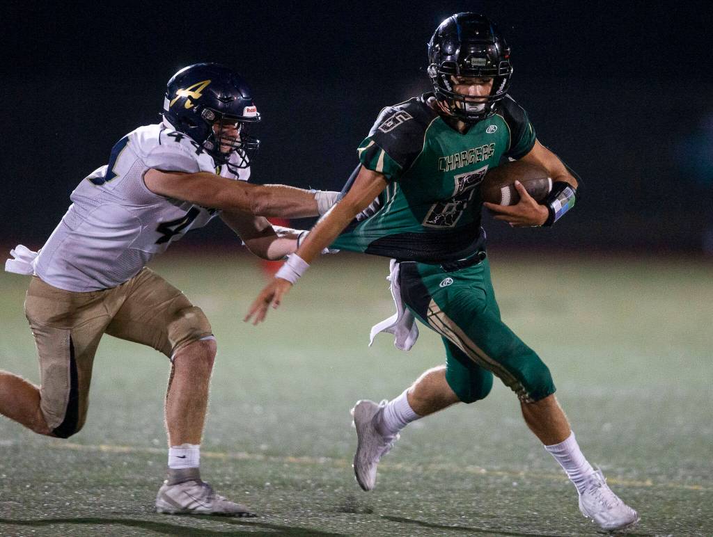 Marysville Getchells Carter Schmidt is tackled by Arlingtons Spencer Fischer during the game on Friday, Sept. 9, 2022 in Marysville, Washington. (Olivia Vanni / The Herald)