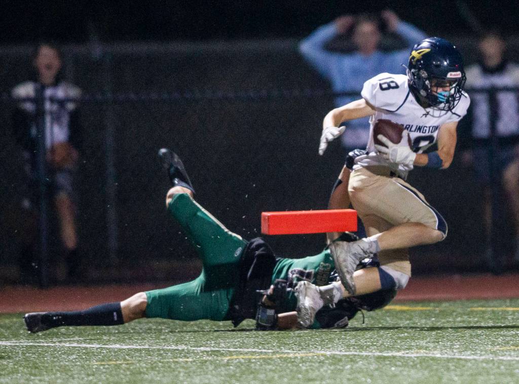 Arlingtons Neil Carroll knocks over a pylon as he is tackled into the end zone for a touchdown during the game against Marysville Getchell on Friday, Sept. 9, 2022 in Marysville, Washington. (Olivia Vanni / The Herald)