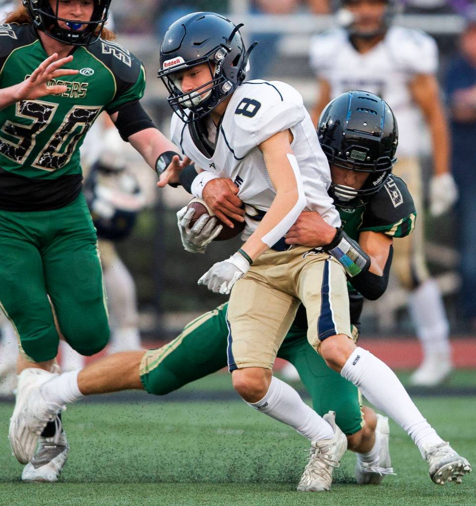 Arlingtons Kaleb Adams is tackled by Marysville Getchells Carter Schmidt during the game on Friday, Sept. 9, 2022 in Marysville, Washington. (Olivia Vanni / The Herald)