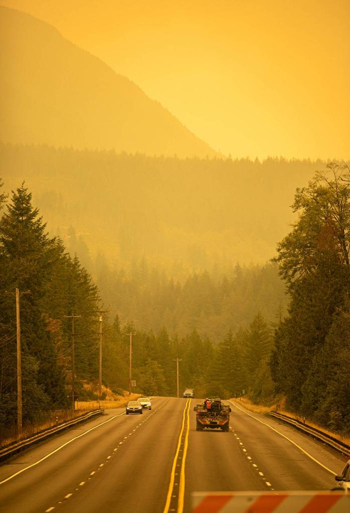 An emergency fire vehicle heads past a barricade and towards Index as numerous agencies attempt to contain the Bolt Creek Fire on Saturday, Sep. 10, 2022, on U.S. Highway 2 near Index, Washington. (Ryan Berry / The Herald)