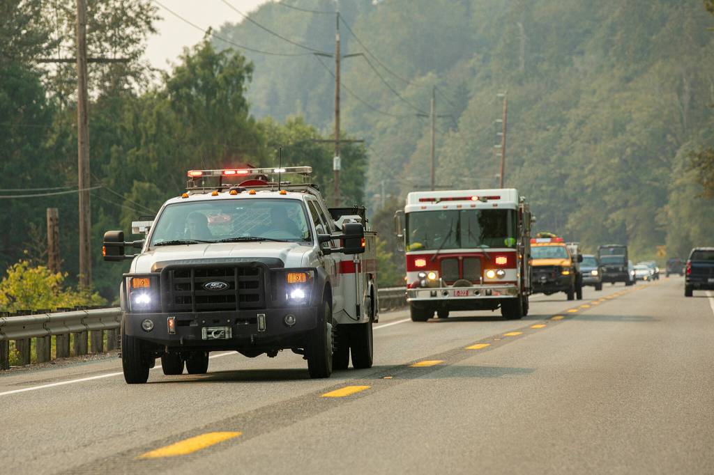 Fire crews from multiple regional agencies speed towards Index along U.S. Highway 2 near Monroe, Washington as the Bolt Creek Fire forces evacuations on Saturday, Sep. 10, 2022. (Ryan Berry / The Herald)