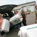 From left, Mary Ayers and Robin Araniva deliver donated wood shavings for animal bedding with the help of Randy Hoyt and Todd McNeal of the Snohomish County Parks Department on Sunday, Sep. 11, 2022, at the Evergreen State Fairgrounds in Monroe, Washington. (Ryan Berry / The Herald)