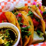 The queso birria tacos at El Mariachi call for slow cooked brisket, melty cheese sandwiched between two corn tortillas, a shower of cilantro and bright pink pickled onions, and a bowl of consomé. (Taylor Goebel / The Herald)
