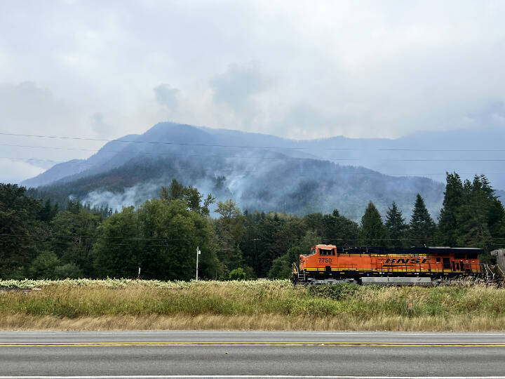 Smoke rises from the Bolt Creek fire as a train passes on Sept. 14, along U.S. 2 between Index and Skykomish. (Peter Mongillo / Snohomish Regional Fire and Rescue)
