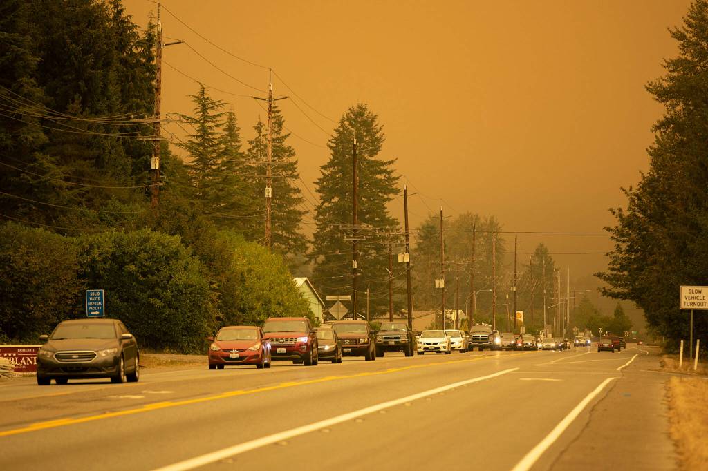 Vehicles evacuate westward through Sultan as road closures and evacuations mount in response to the Bolt Creek Fire on Saturday, Sep. 10, 2022, on U.S. 2 near Sultan, Washington. (Ryan Berry / The Herald)