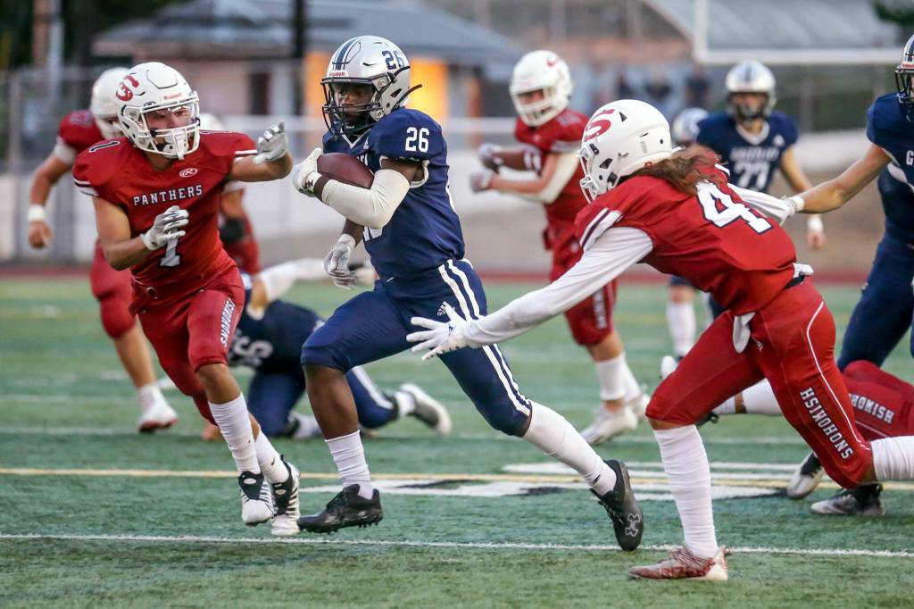 Glacier Peaks Chrisvin Bonshe rushes for yardage with Snohomishs defense closing on Sept. 2 at Snohomish High School. (Kevin Clark / The Herald)