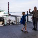 Genghin Carroll, 8, walks up and high fives his mom, Andria Carroll, after riding the ferry over to meet her for a dental appointment on Thursday, Mukilteo. (Olivia Vanni / The Herald)