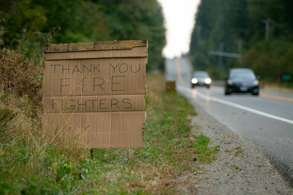 A handmade cardboard sign thanks firefighters for their work along U.S. Highway 2 on Wednesday, near Gold Bar. (Ryan Berry / The Herald)