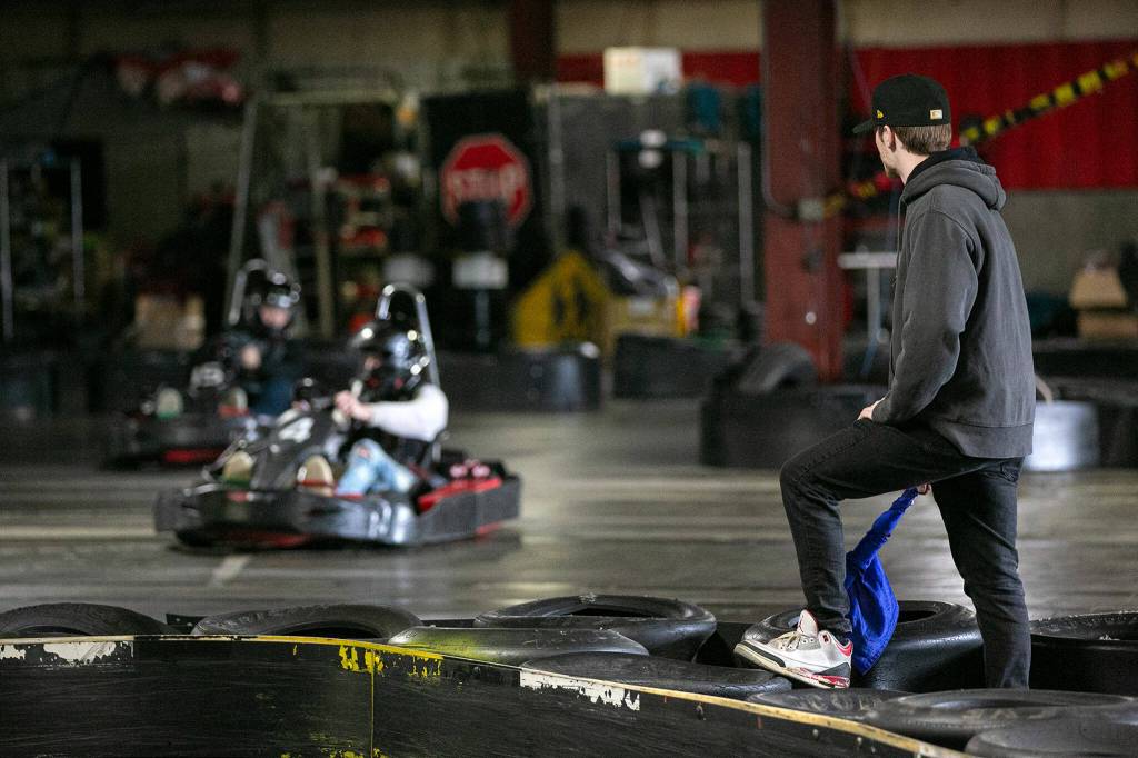 JJ Leonard watches over a race before waving the blue flag at Traxx Indoor Raceway. (Ryan Berry / The Herald)