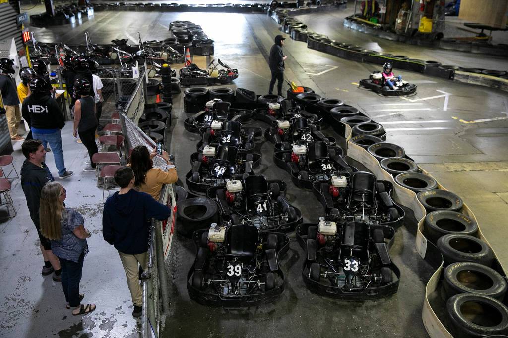 People watch as a young girl finishes her final lap at Traxx Indoor Raceway on Friday. (Ryan Berry / The Herald)