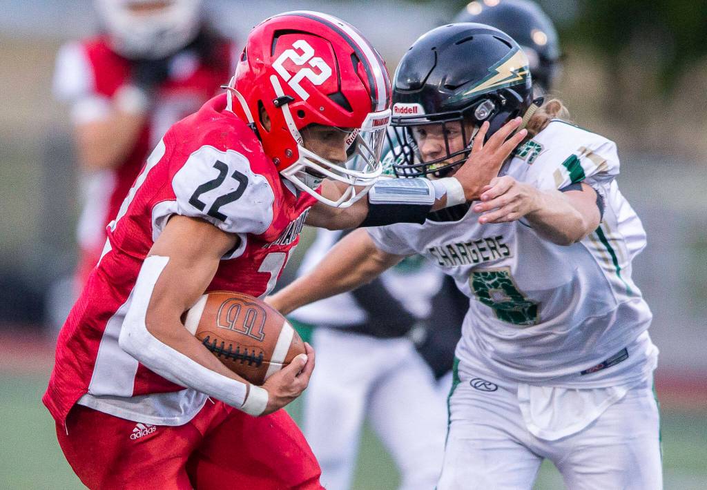 Marysville Pilchucks Joseph Davis sticks out his arm to block a tackle by Marysville Getchells Sean Ewald during the game on Friday, Sept. 16, 2022 in Marysville, Washington. (Olivia Vanni / The Herald)