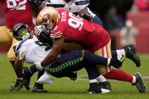 San Francisco 49ers defensive tackle Kevin Givens (90) tackles Seattle Seahawks running back Kenneth Walker III during the second half Sunday. (AP Photo/Tony Avelar)