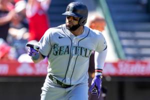 Seattle Mariners' Carlos Santana points to his bench after hitting a grand slam against the Los Angeles Angels during the fifth inning of a baseball game in Anaheim, Calif., Monday, Sept. 19, 2022. (AP Photo/Alex Gallardo)